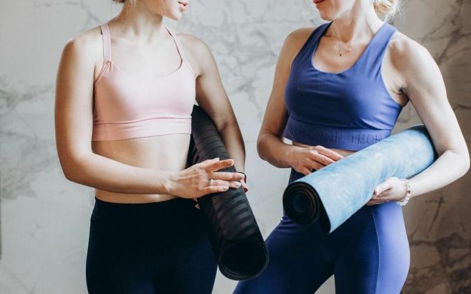 Frauen mit Yoga-Matten sprechen