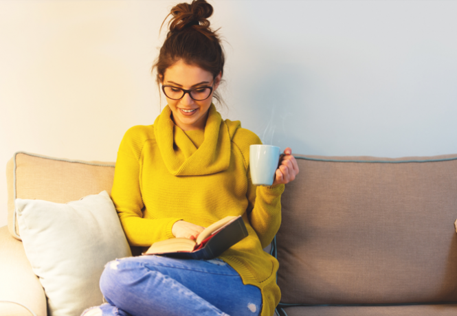 Lesen auf einer Couch mit heißem Getränk