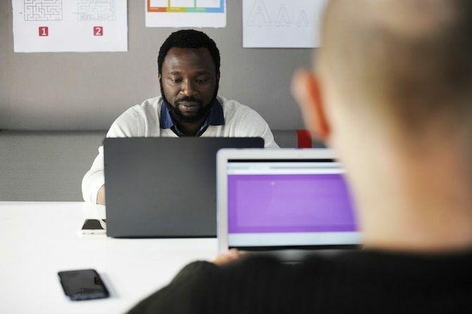 zwei Männer auf Laptops