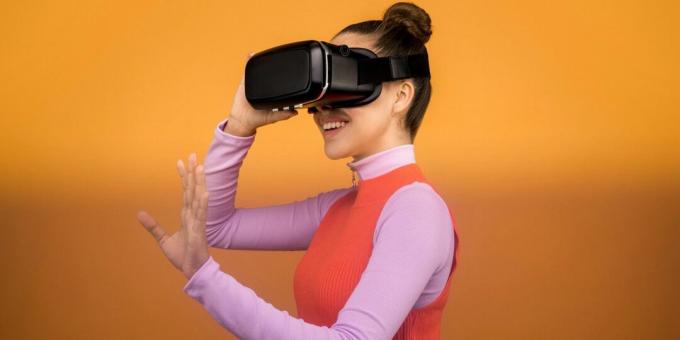 Frau lächelt, während sie ein schwarzes Virtual-Reality-Headset trägt