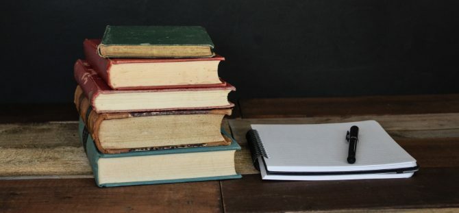 Stapel Bücher und Notizblock für die Forschung